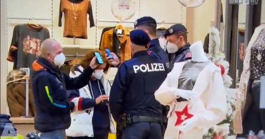 Para petugas kepolisian negara Austria sedang memeriksa anggota masyarakat kartu vaksin.