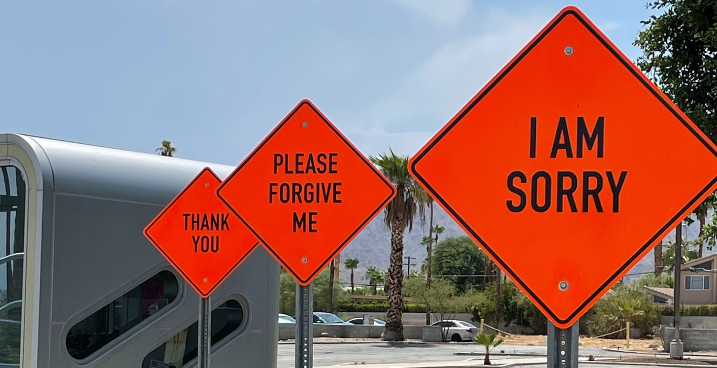 Three orange signs in a row. One saying I am sorry, the next Please forgive me, and the last Thank you