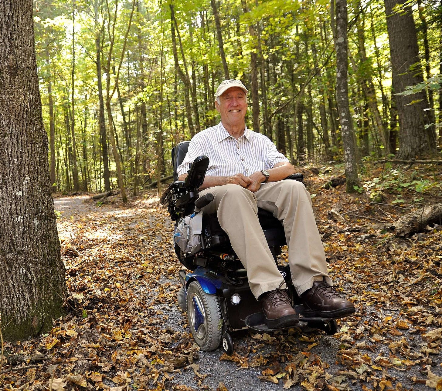 Tim Barnett, an older white man using a powerchair, on Tim’s Trail, which is named for him and a wheelchair accessible trail at The Nature Conservancy’s Willsboro preserve.