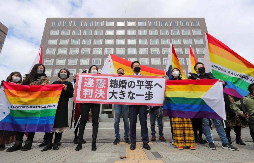 Supporters hold the  unconstitutional decision  flag as they are pleased with the Sapporo District Court's decision that it is unconstitutional to not allow same-sex marriage in Sapporo, Hokkaido prefecture on March 17, 2021.