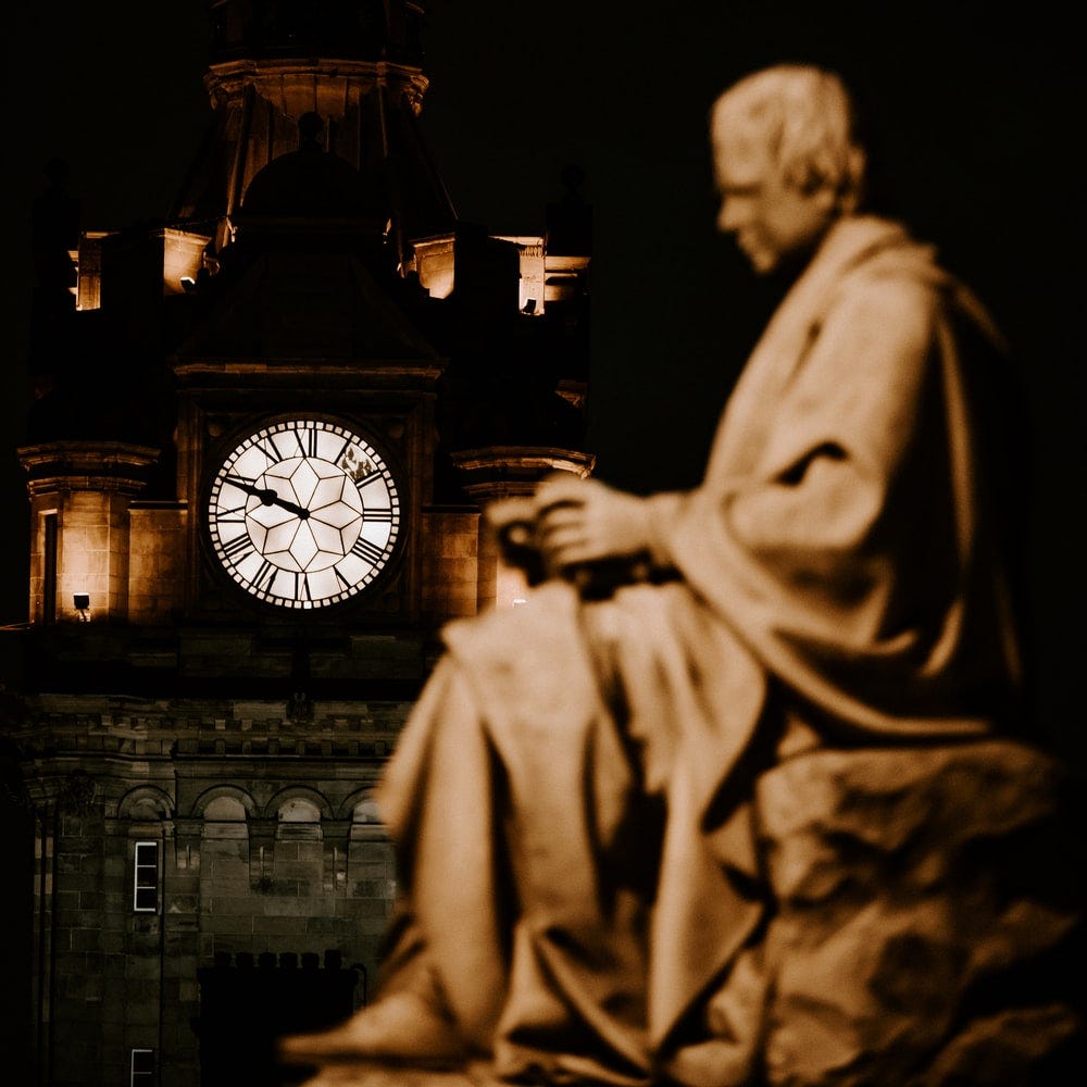 grey analog clock near statue