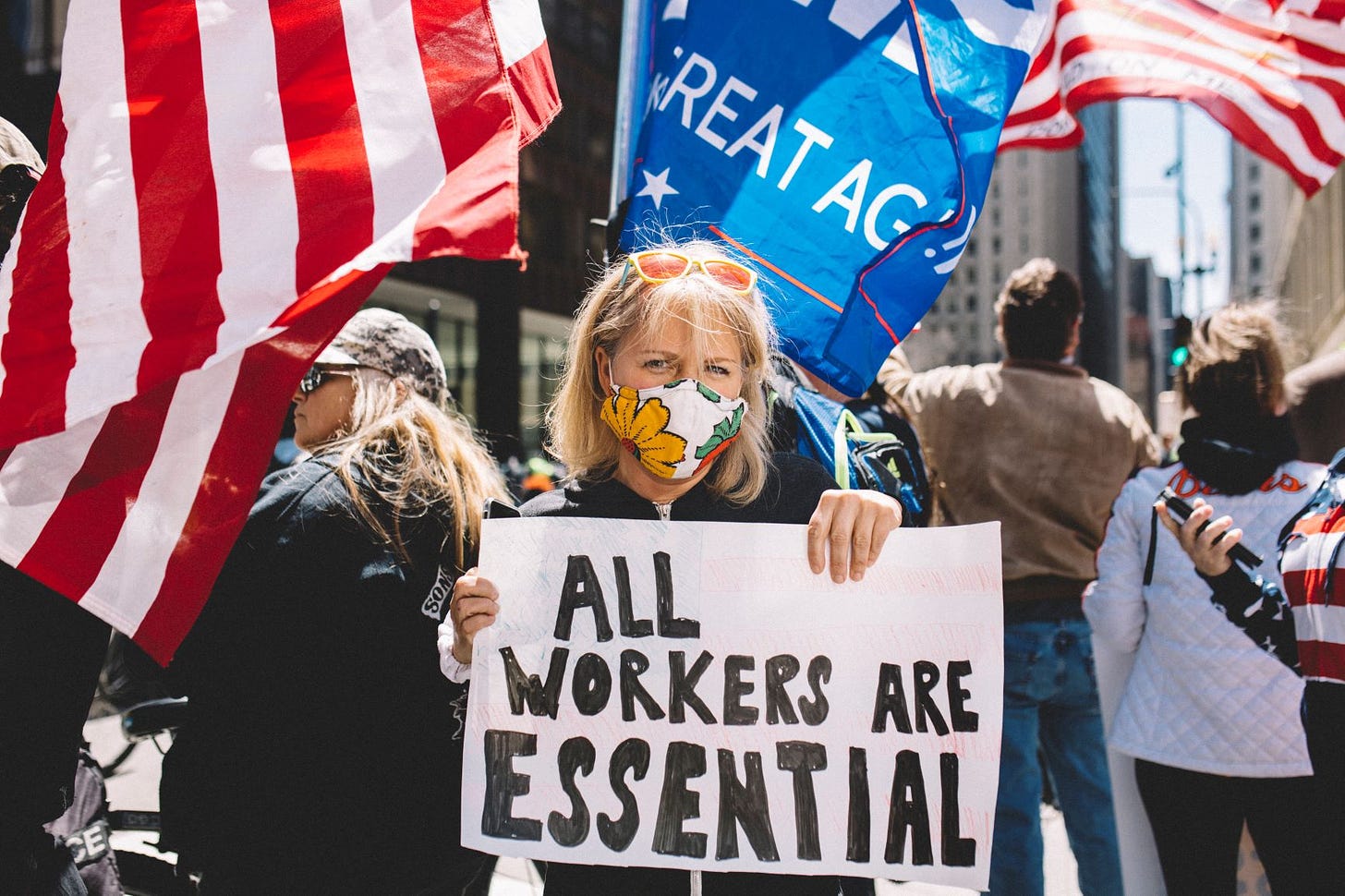 Mulher protesta em Chicago com cartaz "Todos os trabalhadores são essenciais": manifestantes não falam de pobreza (Jim Vondruska/NurPhoto/AFP)