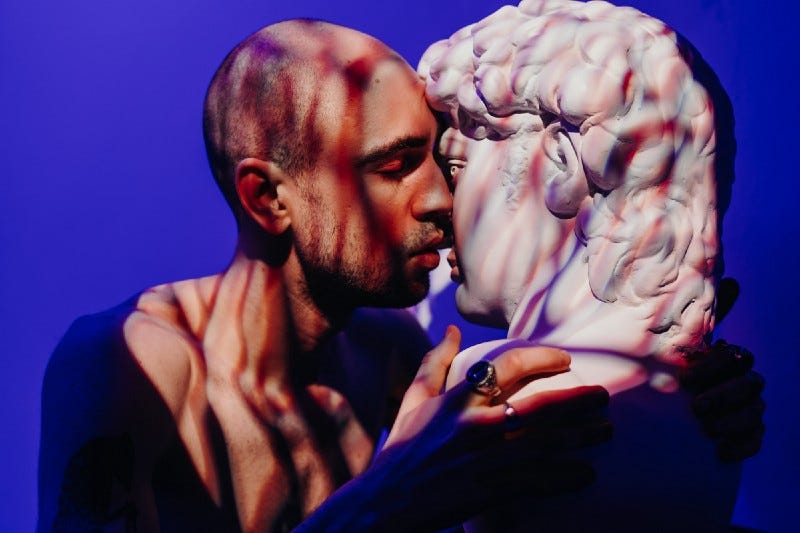 A man kisses a marble statue