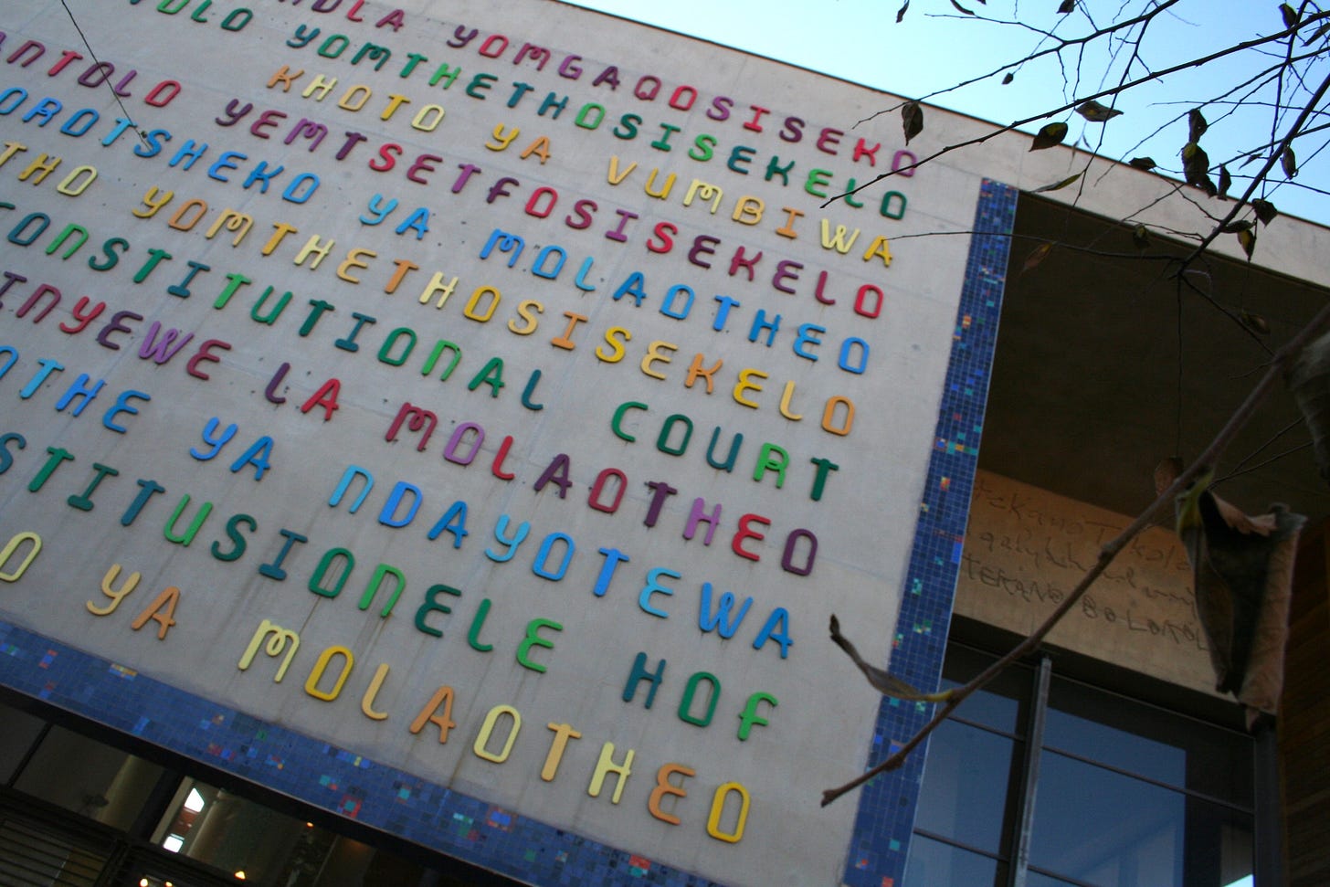 South African Constitutional Court exterior wall where the words “Constitutional Court” are written in the 11 official languages of South Africa. Author Photograph. July 2, 2022.