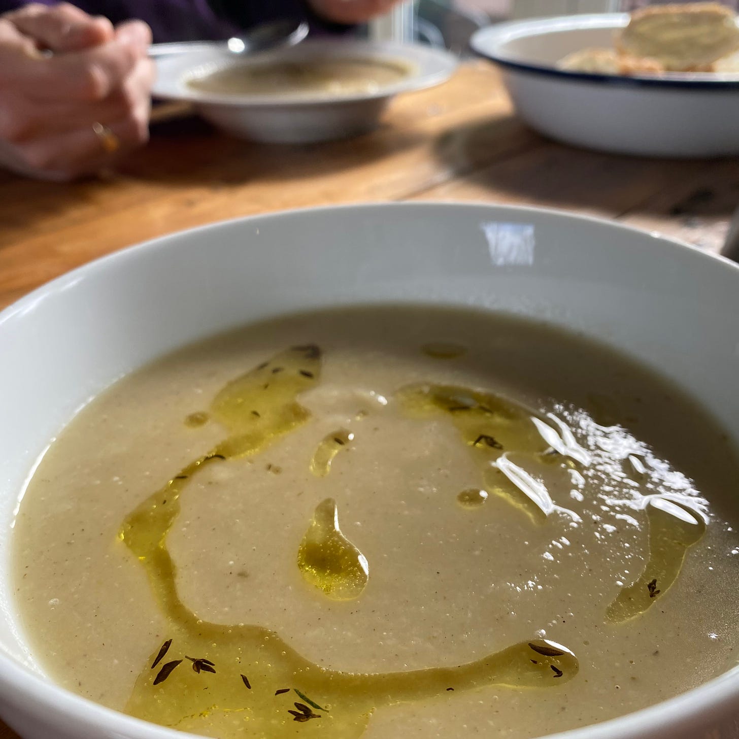 Bowl of parsnip and apple soup drizzled with thyme oil