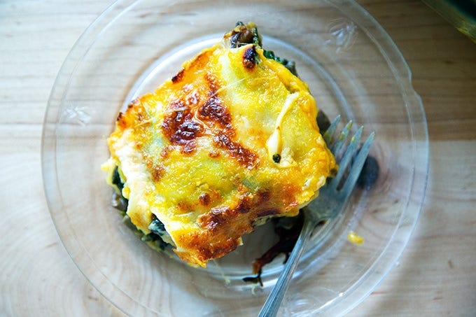 A slice of butternut squash lasagna with greens and mushrooms.