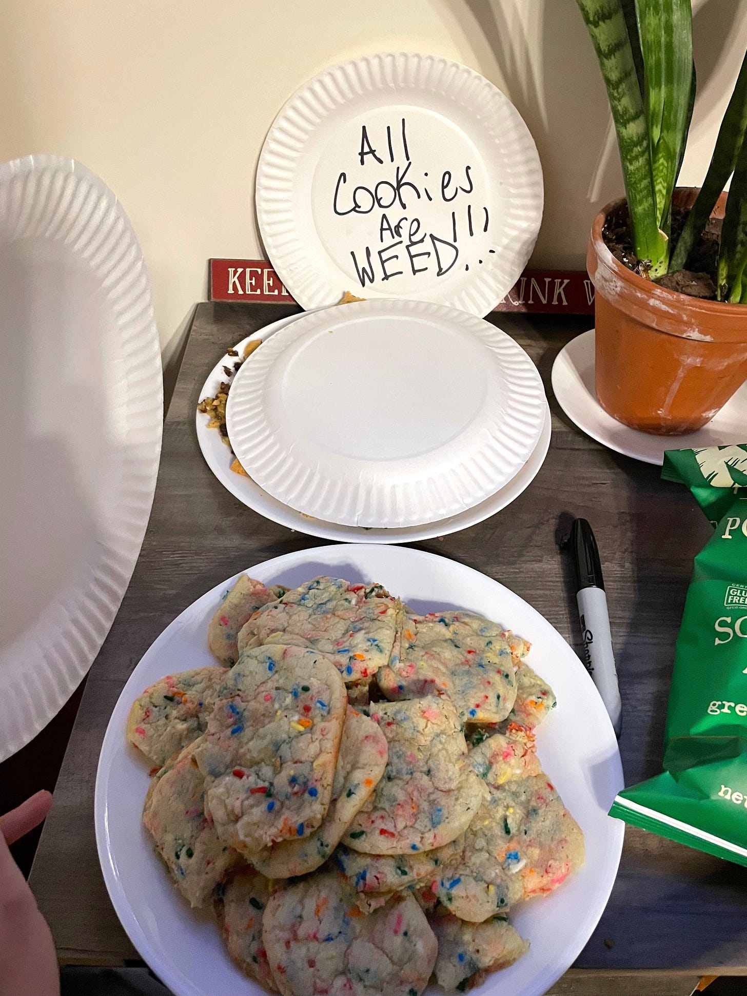 paper plate of cookies next to a paper plate with "All cookies are weed" written on it
