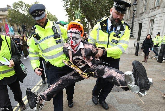 A dossier of files from within XR reveals the inner workings of the protest movement and its finances. One protester is pictured being taken away by police in Westminster, London earlier this week