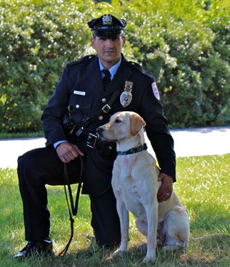 Socks, one of the famous Penn Vet Working Dogs, with Officer DePallo.
