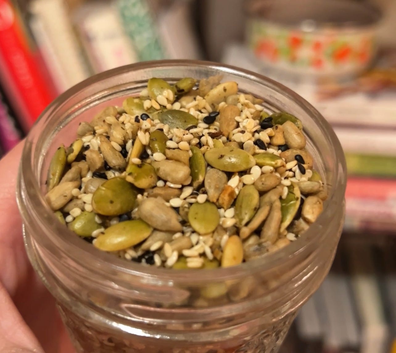sesame seeds, pepitas, sunflower seeds in a glass jar.
