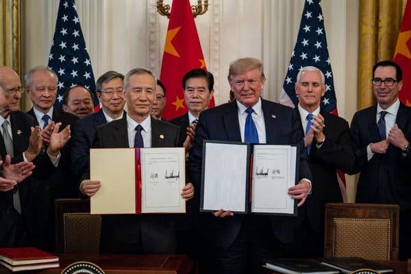 President Trump, along with China’s top trade envoy, Liu He, displaying the signed trade deal on Wednesday.