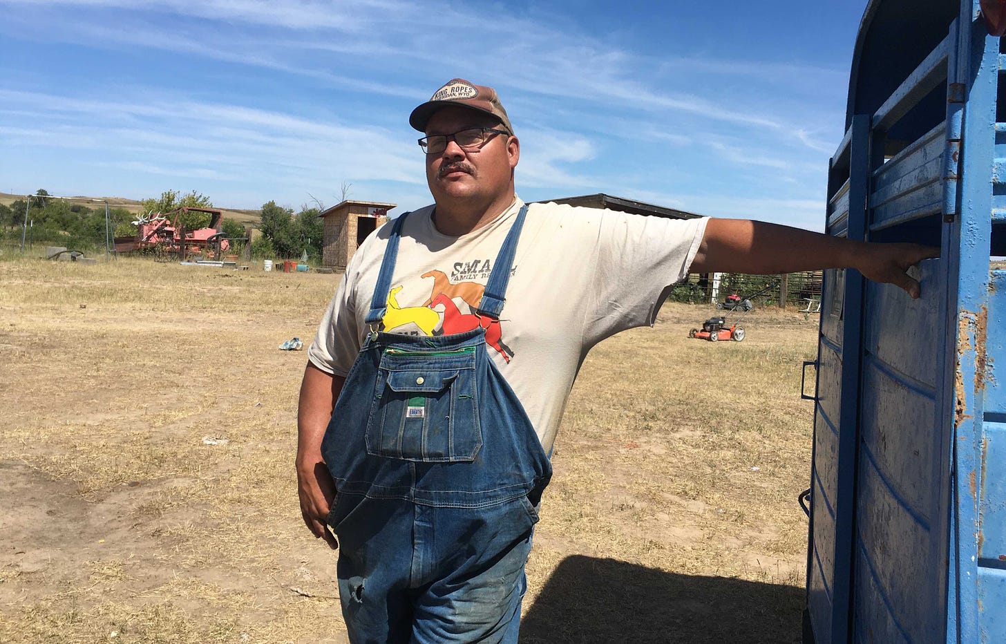 large man in overalls on his ranch land