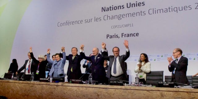 World leaders celebrate signing the Paris climate agreement at a conference in 2015