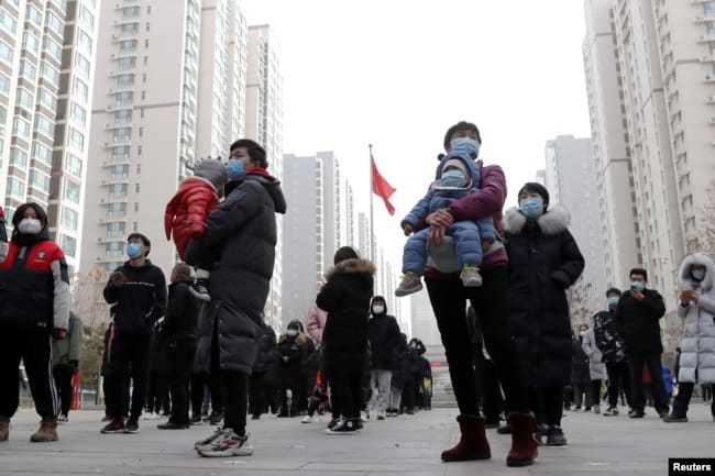 People practice social distancing as they line up for a second round of citywide nucleic acid testing at a residential compound, following new COVID-19 cases in Shijiazhuang, Hebei province, China on Jan. 12, 2021.
