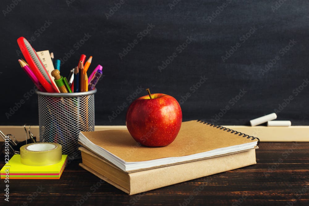 Teacher's desk with writing materials, a book and an apple, a blank for  text or a background for a school theme. Copy space. Stock Photo | Adobe  Stock