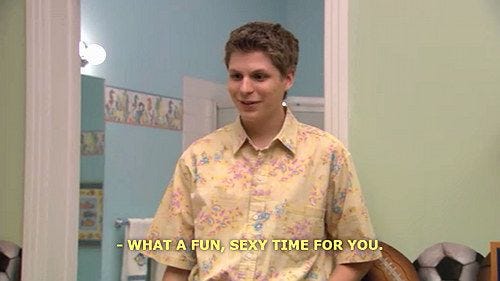 A still of Michael Cera in "Arrested Development" in a sage-colored bedroom wearing a yellow flowered shirt saying "What a fun, sexy time for you."