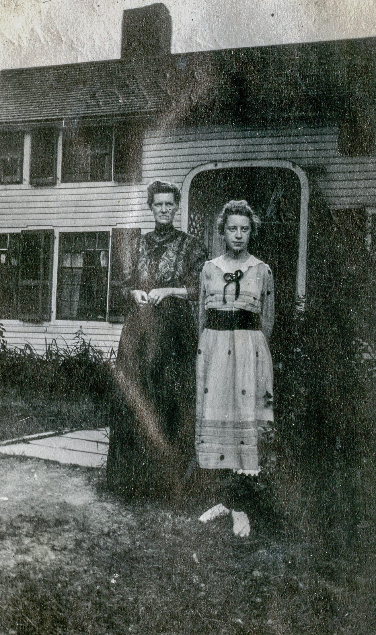 Two women in front of house