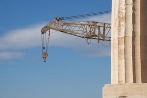 Crane appearing from behind marble Parthenon column.jpg