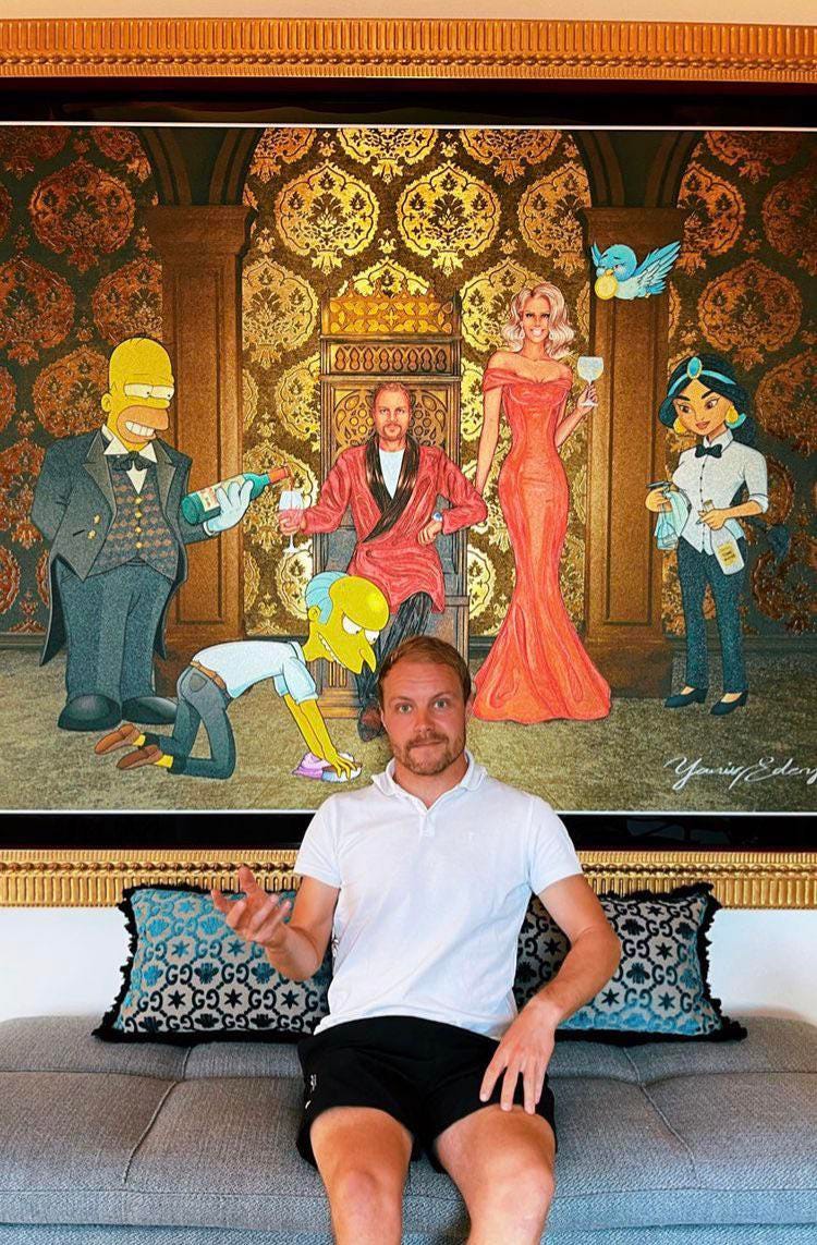 Bottas posing with a portrait of himself being served by Simpsons characters nd Jasmine from Aladdin. I'm not sure how else to describe this.