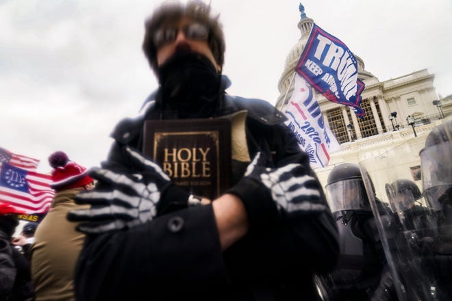 In this Wednesday, Jan. 6, 2021 file photo, a man holds a Bible as President Donald Trump's supporters gather outside the Capitol in Washington.