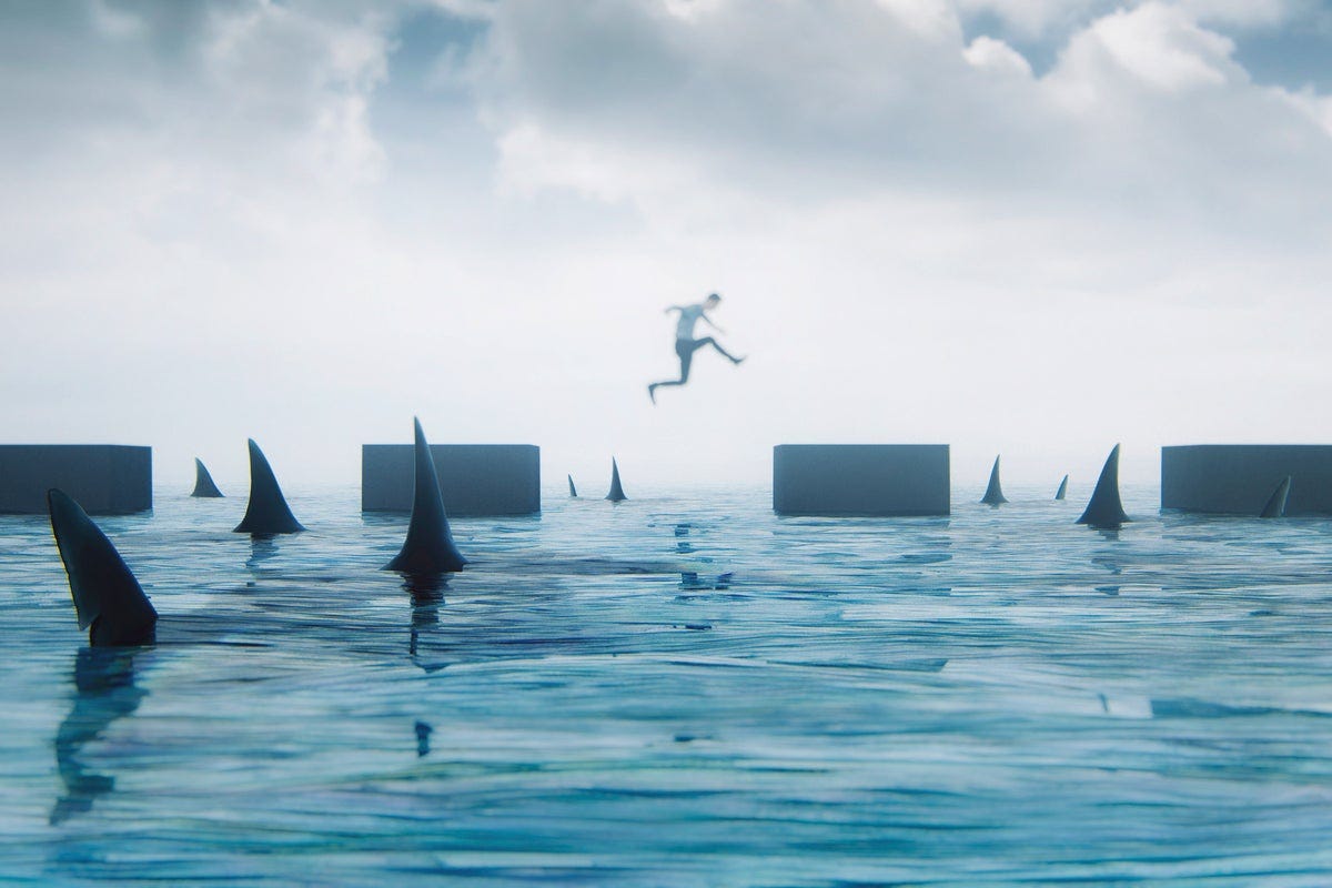 A person leaps between platforms surrounded by sharks. [danger / risk / challenges]