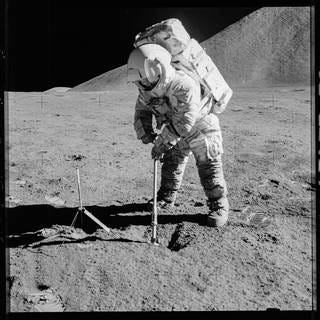 Apollo astronaut on the moon, covered in lunar dust.