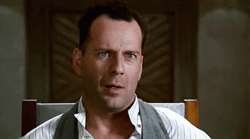 A gif of Bruce Willis smiling then looking confused then smiling again