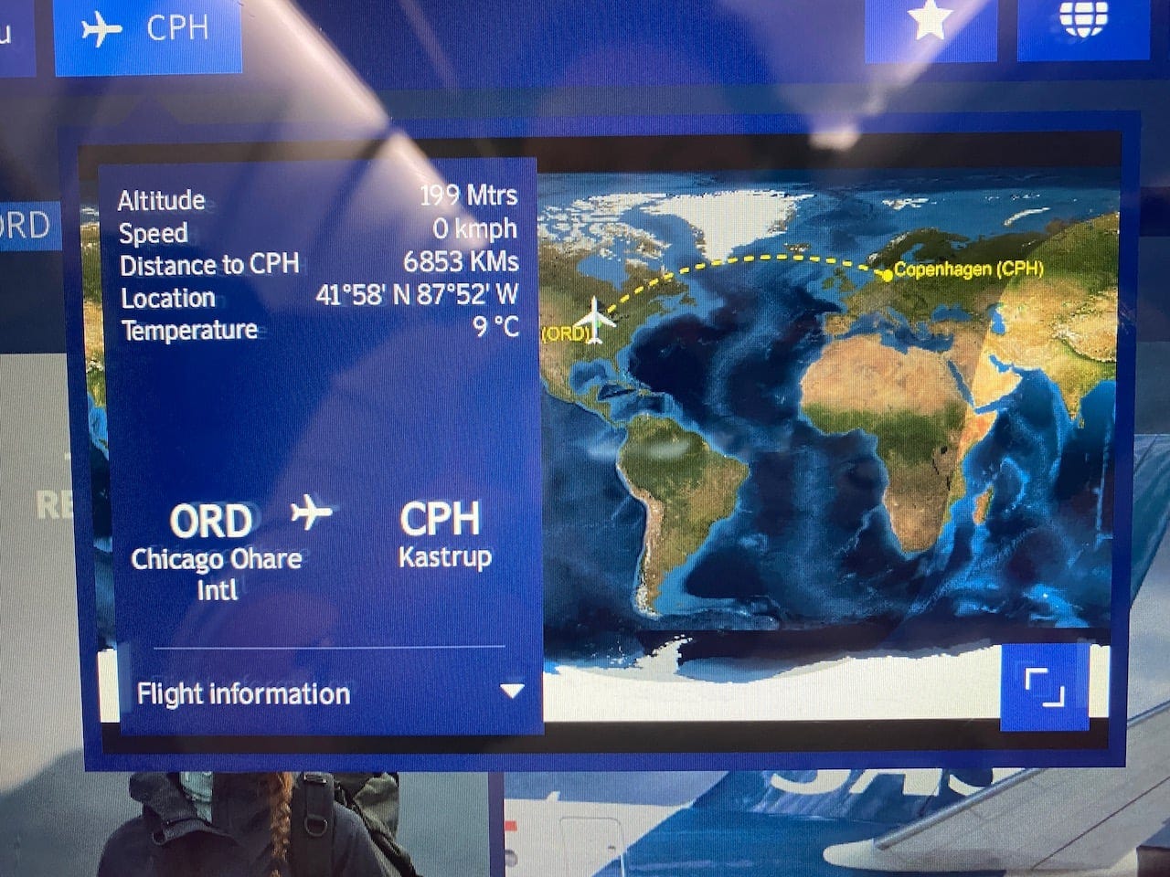 electronic display on the seatback showing flight information for SAS flight 944 with non-stop service from Chicago O'Hare to Copenhagen Kastrup