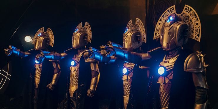 This image shows four CyberMasters standing in a row and pointing their right arm blasters at the offscreen Doctor. This image shows four CyberMasters standing in a row and pointing their right arm blasters at the offscreen Doctor.