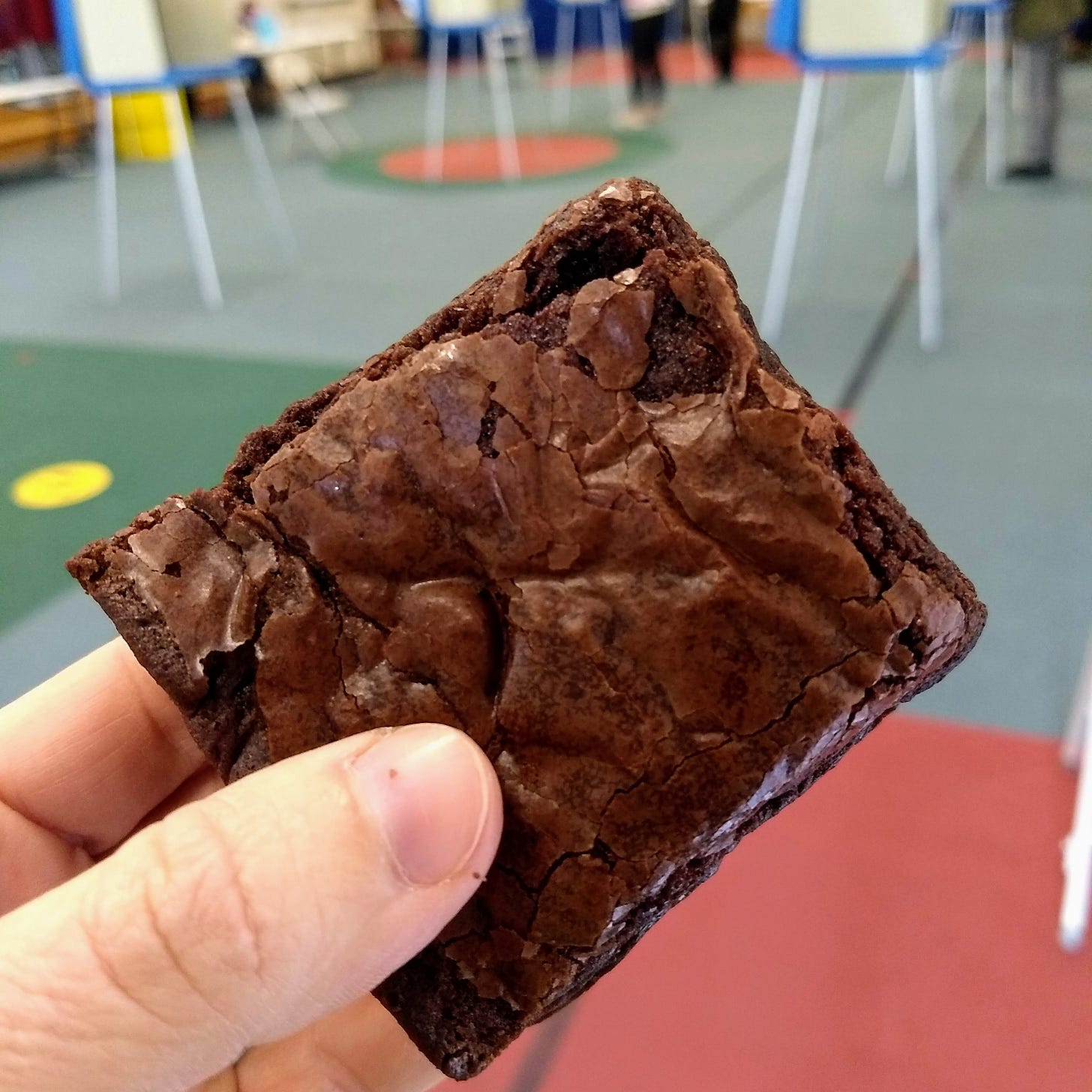 A homemade brownie, with polling booths in the background.