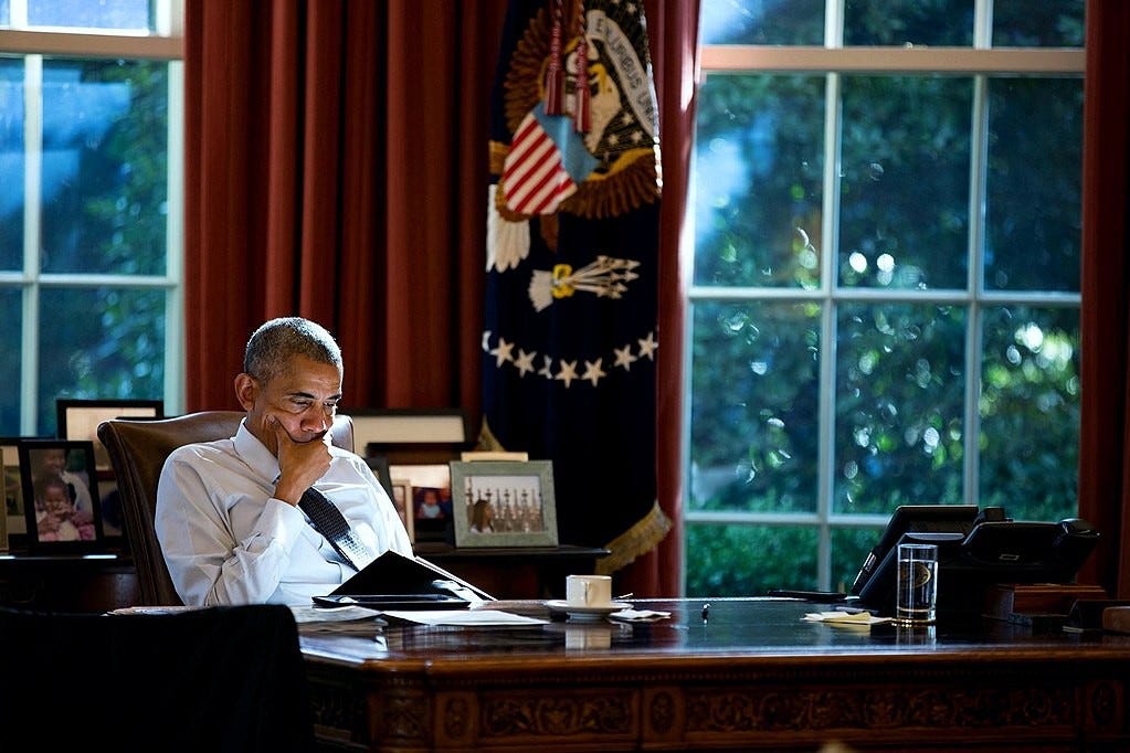A photo of President Obama reading in the Oval Office.