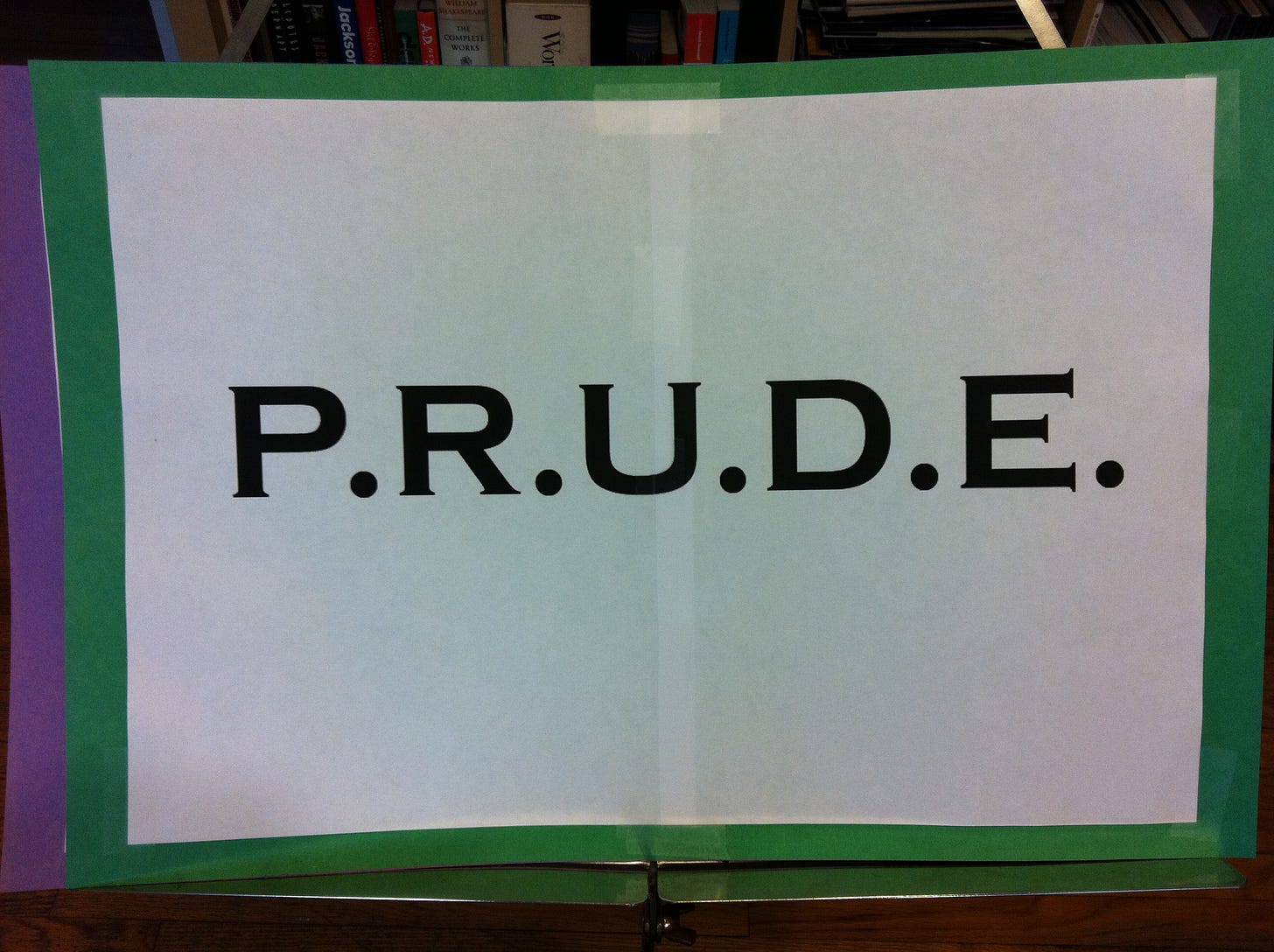 A sign mounted on green construction paper reads: "P.R.U.D.E."
