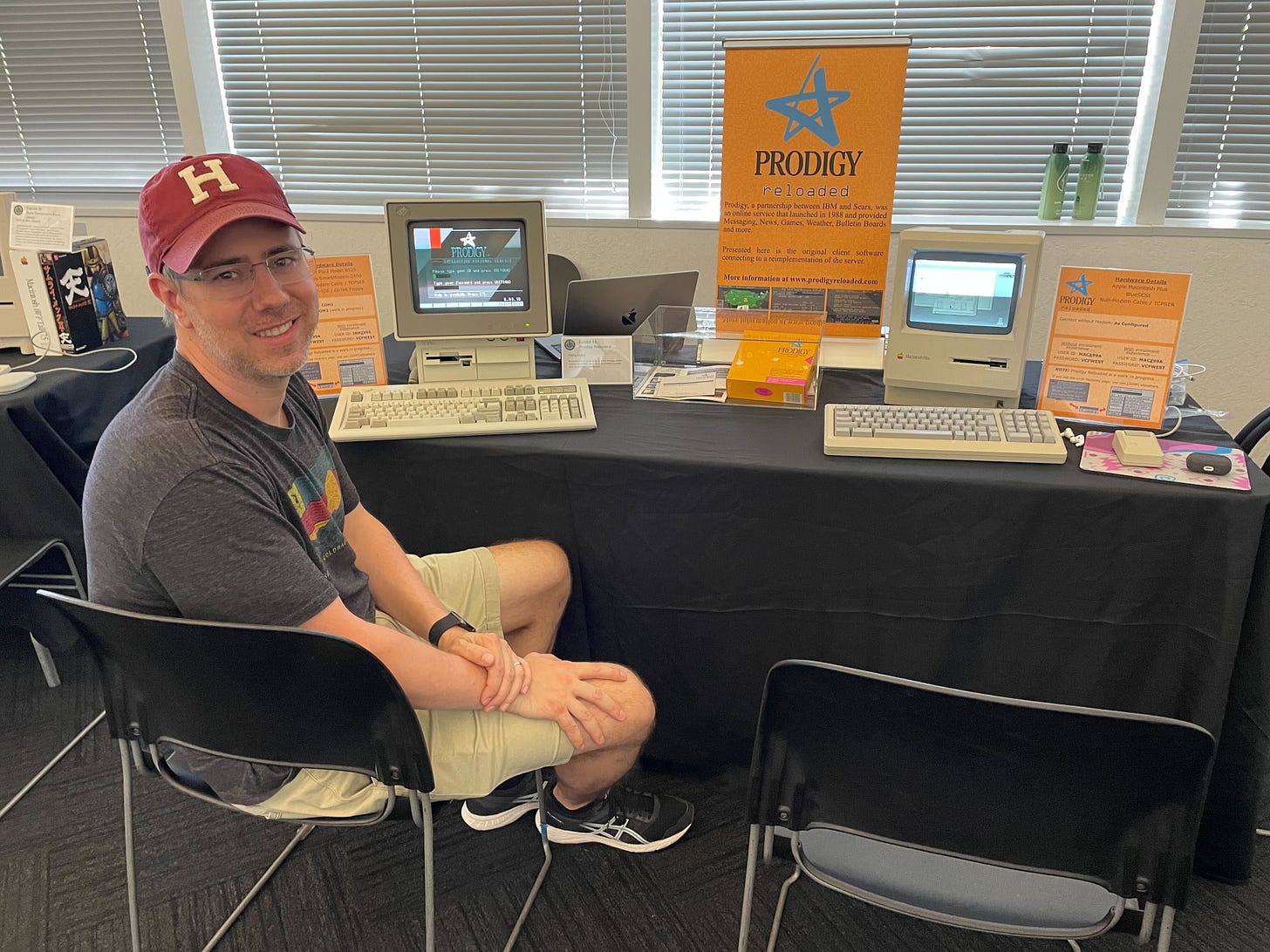 Phil Heller sitting at a Prodigy Reloaded exhibit table at VCF West 2022.