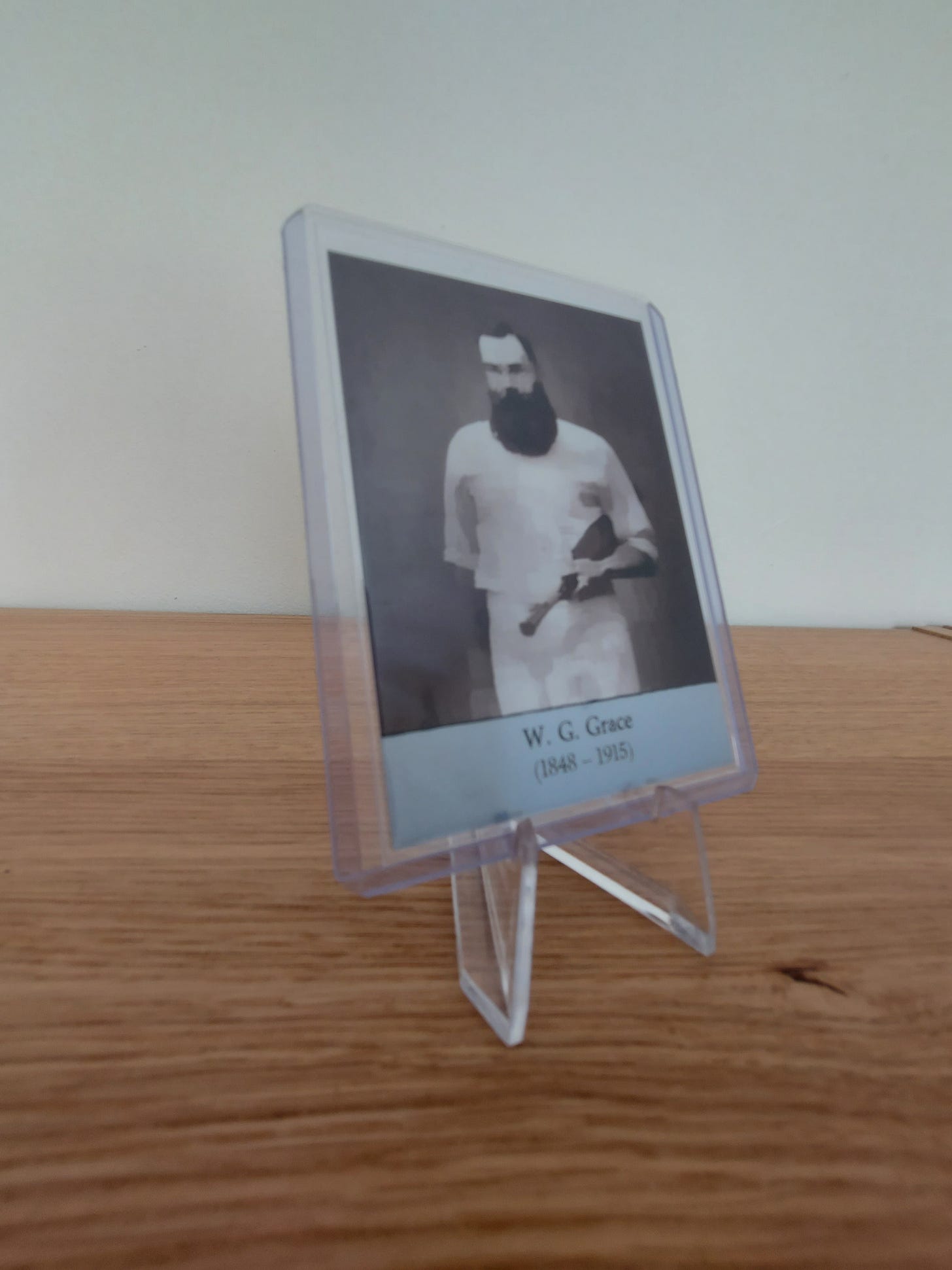 W.G. Grace trading card, in protective toploader on easel display on desk.