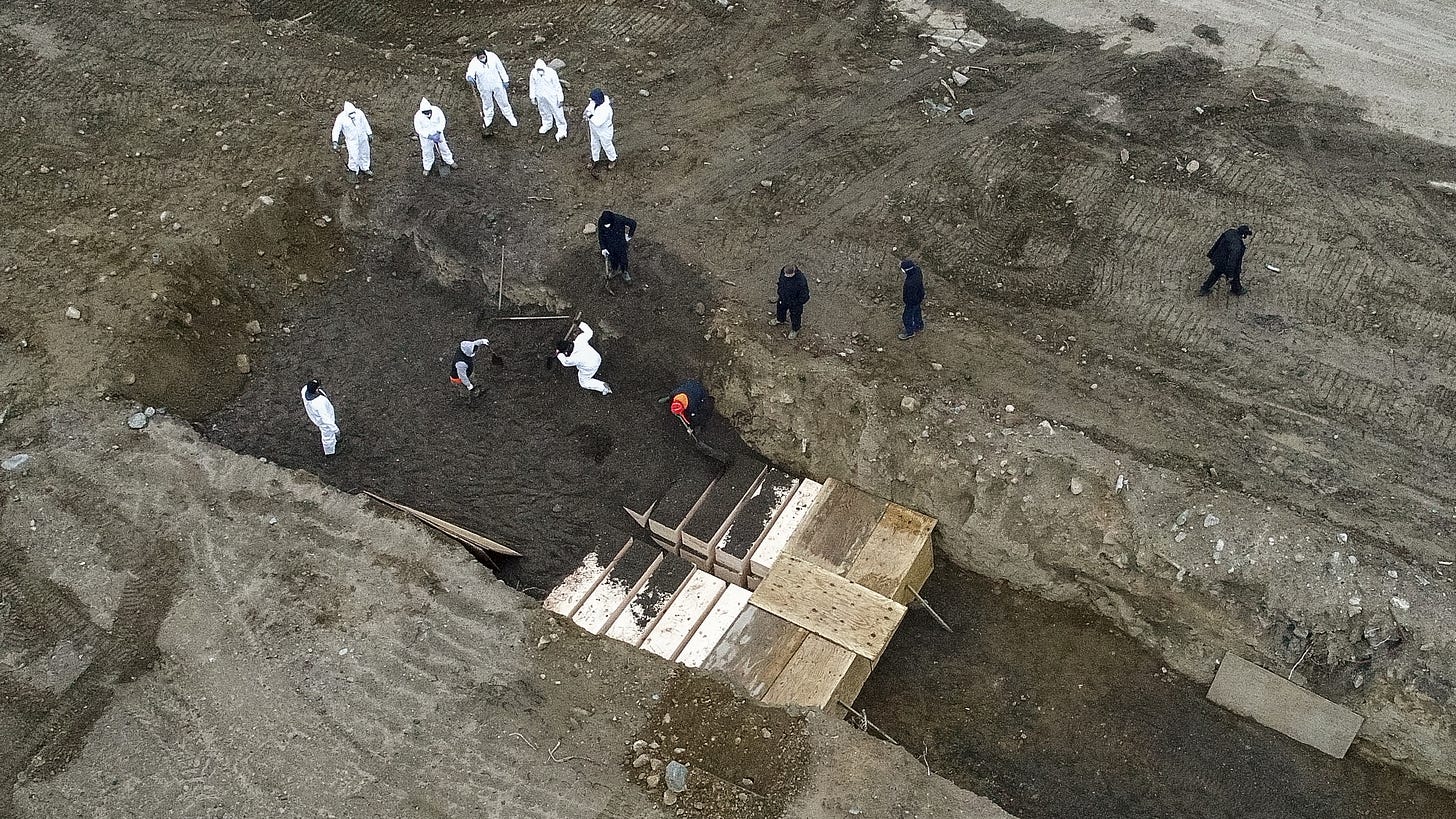 Workers in NYC filling a mass grave of COVID victims in March of 2020