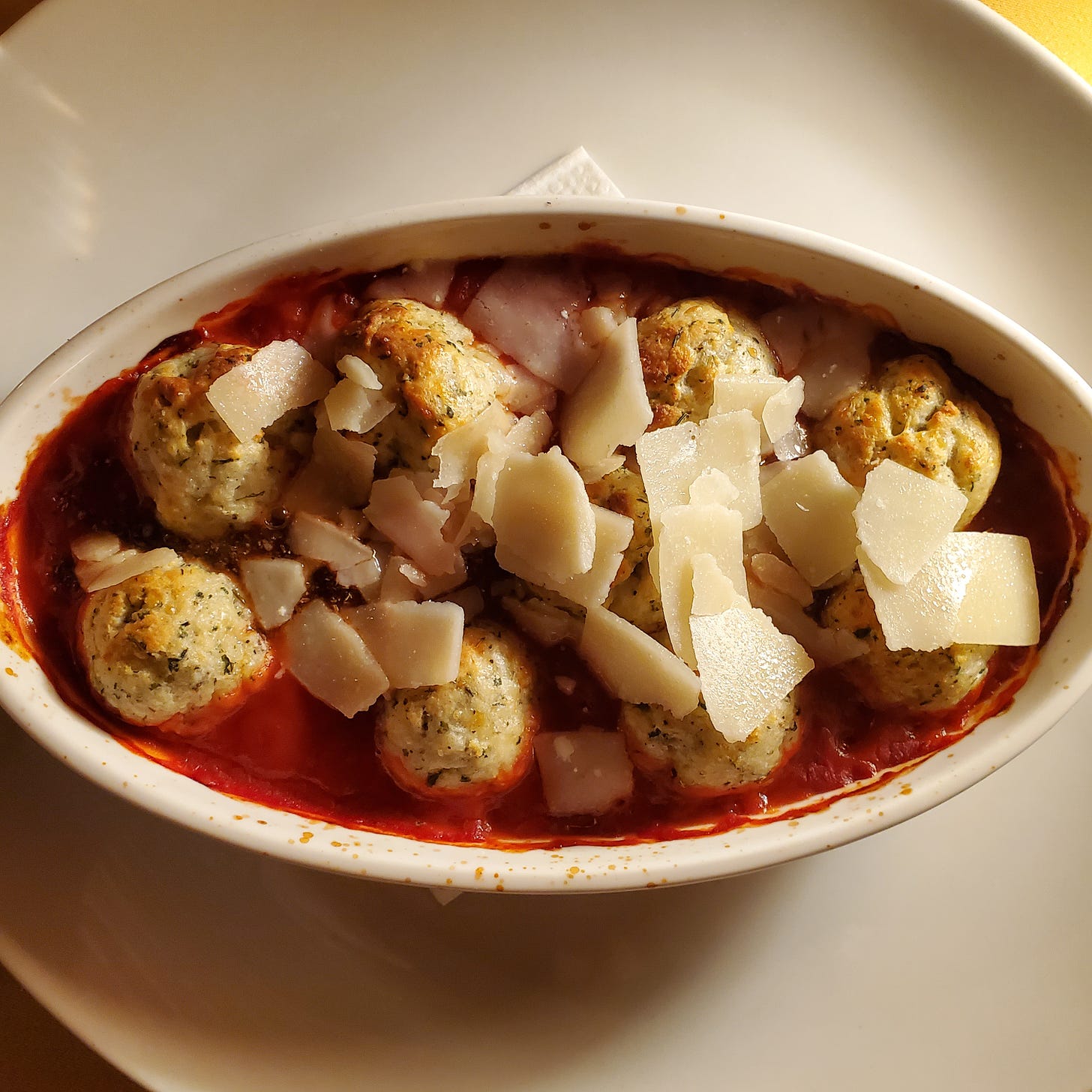 Little round dumplings in tomato sauce with shaved cheese.