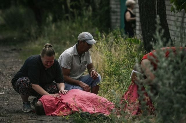 A woman mourns over the body of her relative who was reportedly killed by a cluster rocket in the city of Lysychansk in the eastern Ukrainian region of Donbas on June 18, 2022 amid the Russian invasion of the country