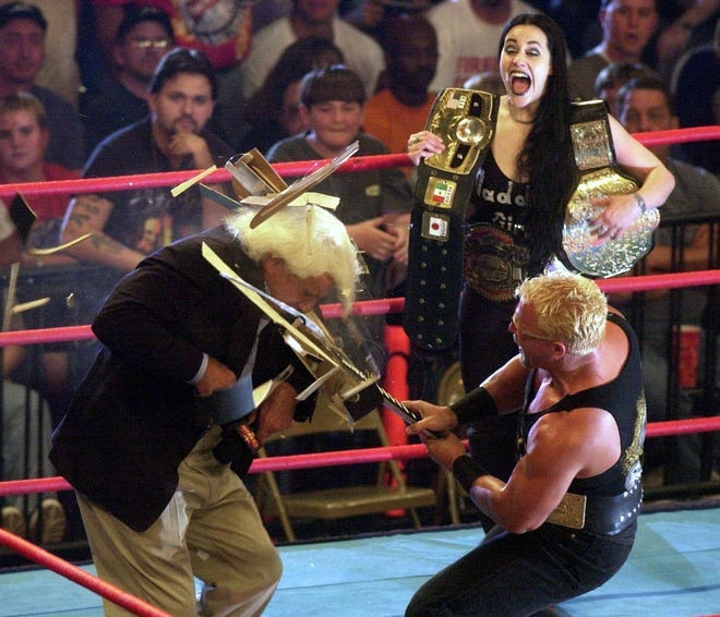 Daffney Unger looks on as Jeff Jarrett, right, smashes a guitar over the head of Ric Flair during WCW's Monday Nitro on May 15, 2000.