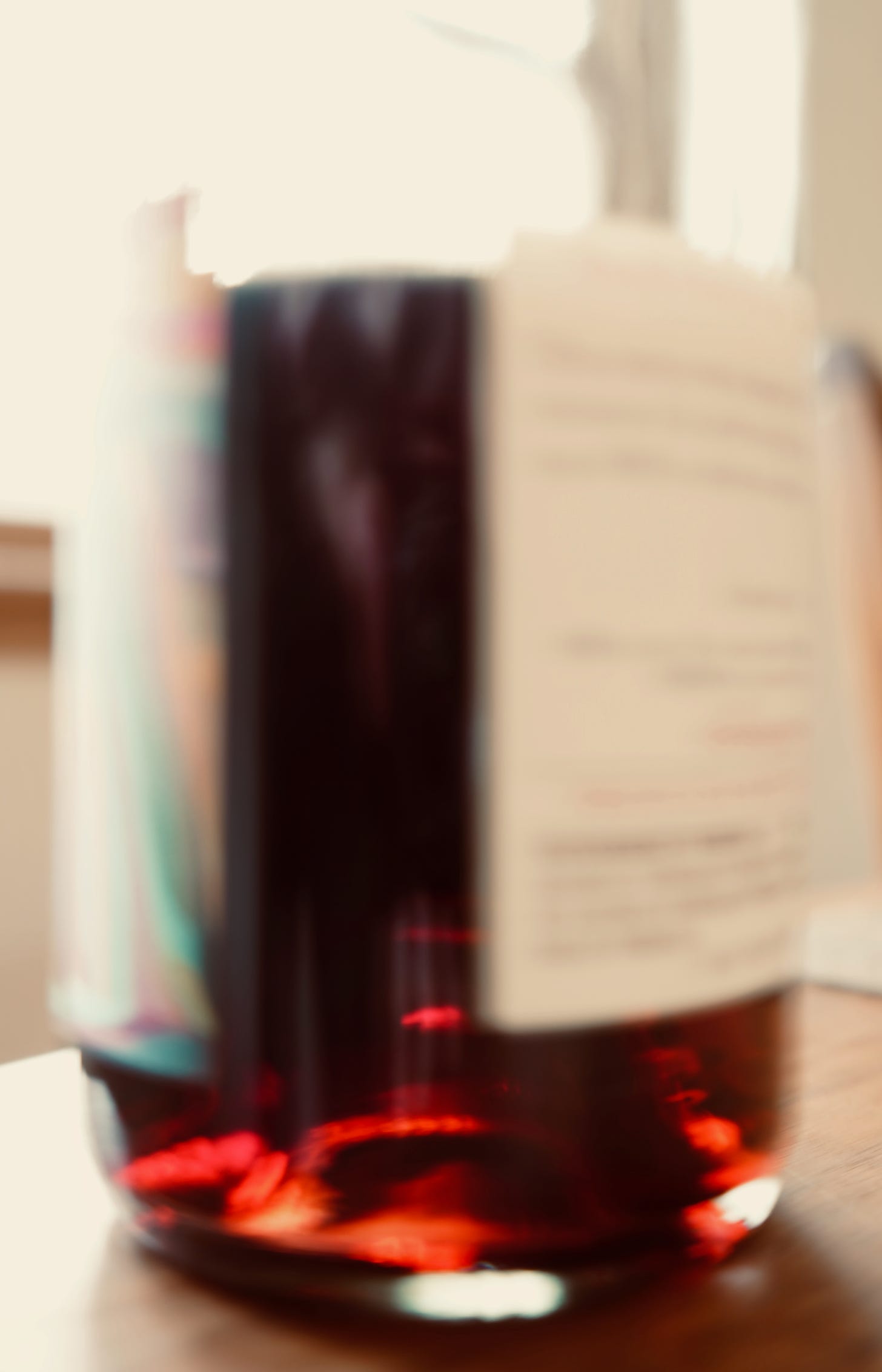 Blurry and overexposed photo of a half empty bottle of wine