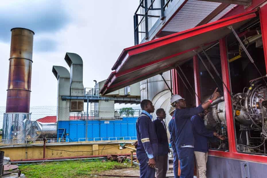 Mechanics attend to a 25-megawatt gas turbine plant that powers the camp