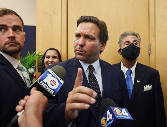 Florida Gov. Ron DeSantis responds to reporters’ questions Monday in Miami.