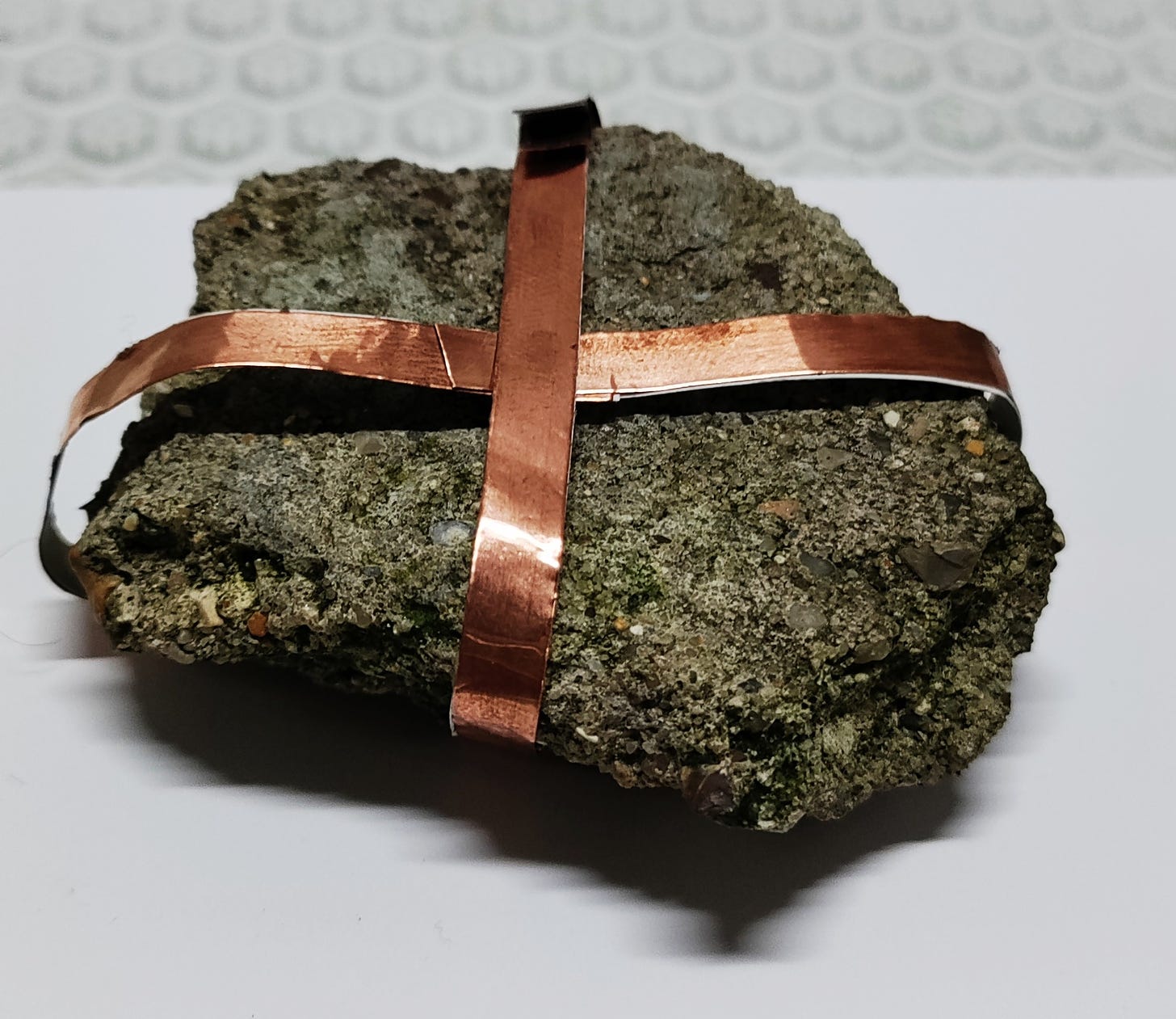 a stone gift wrapped in copper tape
