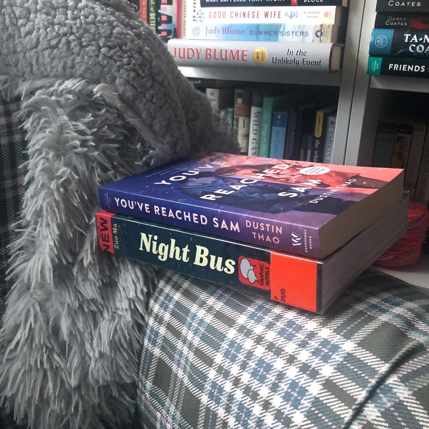 The books Night Bus and You've Reached Sam sitting on a comfy chair