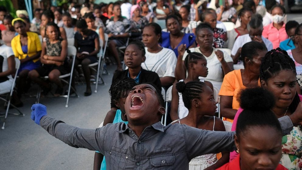 A parishioner shouts "Hallelujah" during a mass on the grounds next to an earthquake-damaged church in Les Cayes, Haiti, Sunday, Aug. 22, 2021. (AP Photo/Matias Delacroix)