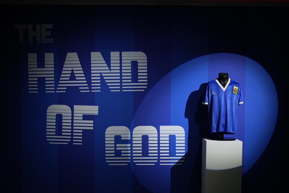 FILE - The Argentina football shirt worn by Diego Maradona in the 1986 Mexico World Cup quarterfinal soccer match between Argentina and England, is displayed for photographs at Sotheby's auction house, in London, Wednesday, April 20, 2022. The shirt worn by Maradona when he scored the controversial “Hand of God” goal has sold for 7.1 million pounds ($9.3 million), the highest price ever paid at auction for a piece of sports memorabilia. Auctioneer Sotheby’s sold the shirt in an online auction that closed Wednesday, May 4, 2022. (AP Photo/Matt Dunham, File)
