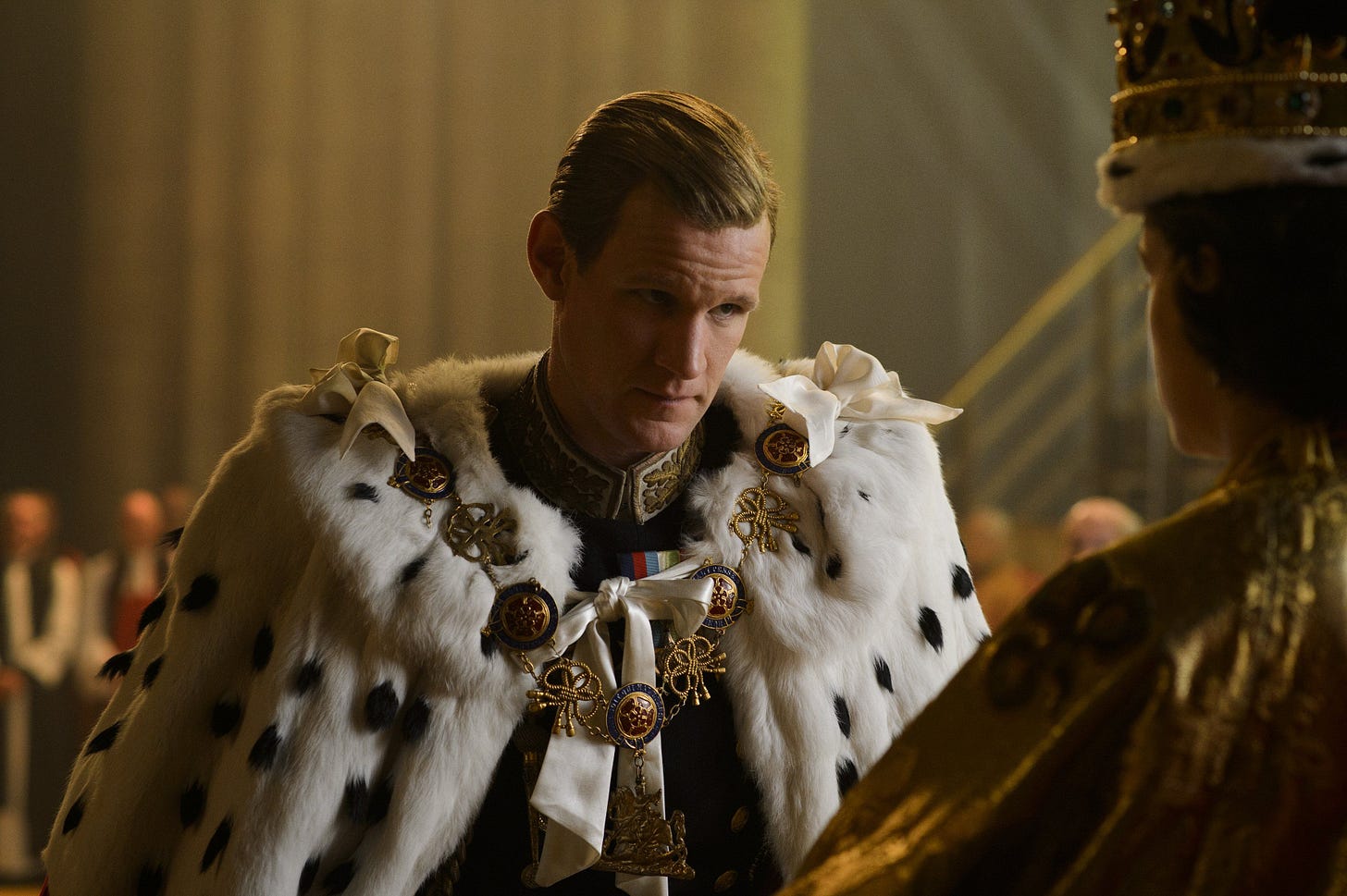 Philip (Matt Smith) kneeling in front of Queen Elizabeth at her coronation.