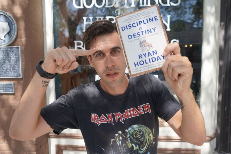 Ryan Holiday holds up a copy of his book, "Discipline is Destiny."