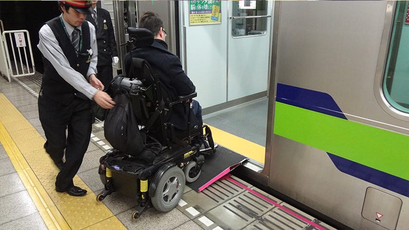 Person in a wheelchair being wheeled onto a train in Japan