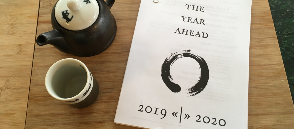 A Japanese tea pot and cup next to the printed ‘Year Ahead’ booklet from yearcompass.com