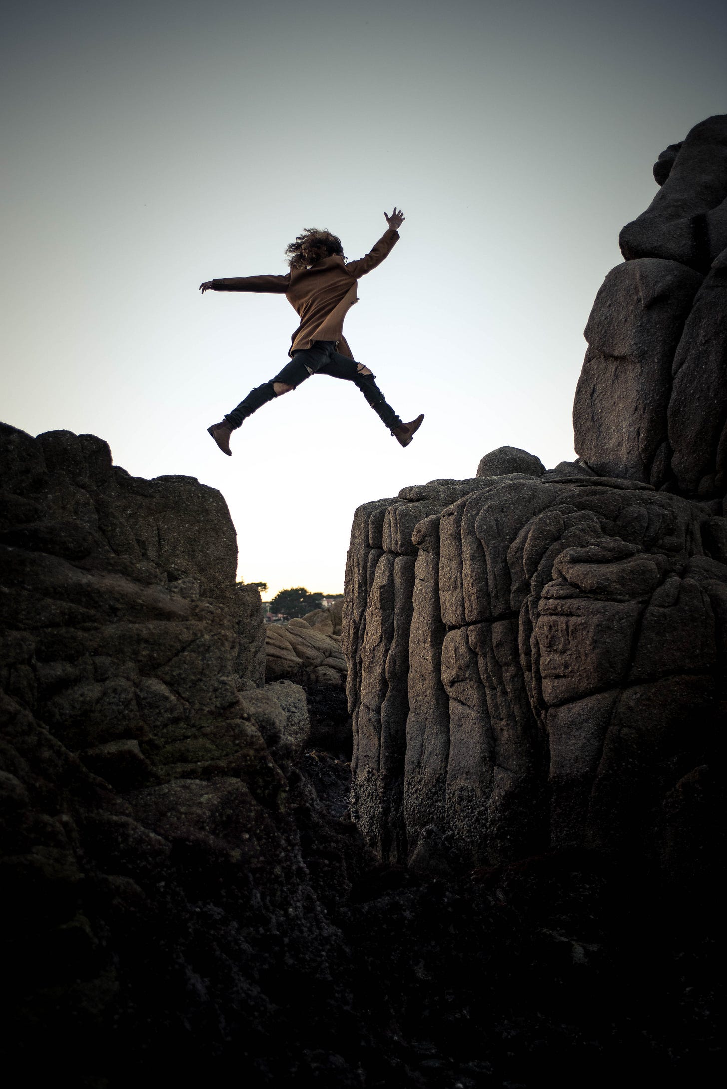 Person jumping on big rock fearlessly